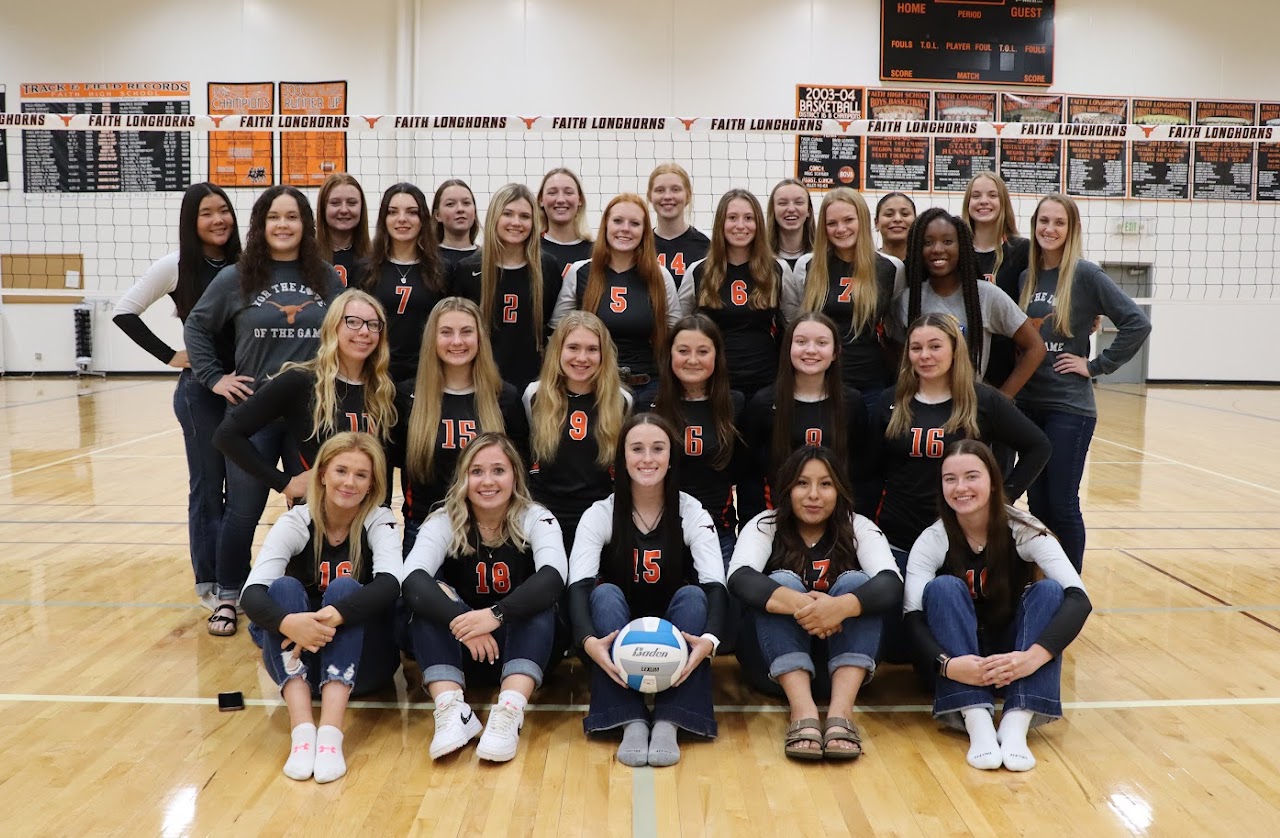 Volleyball team photo in gym in front of volleyball net
